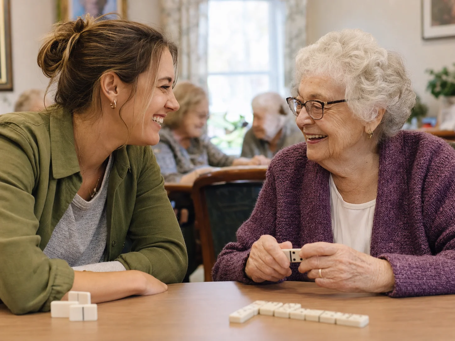 A visitor sharing laughter and a game with a nursing-home resident